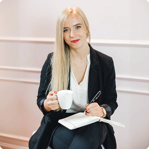 Kollegin mit Notizbuch und Kaffeetasse im Büro