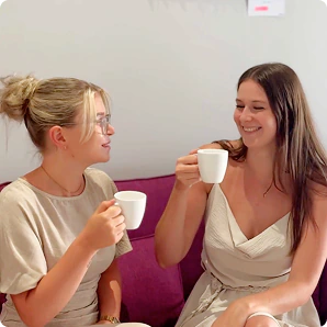 Zwei Kolleginnen in der Kaffeepause auf dem Sofa